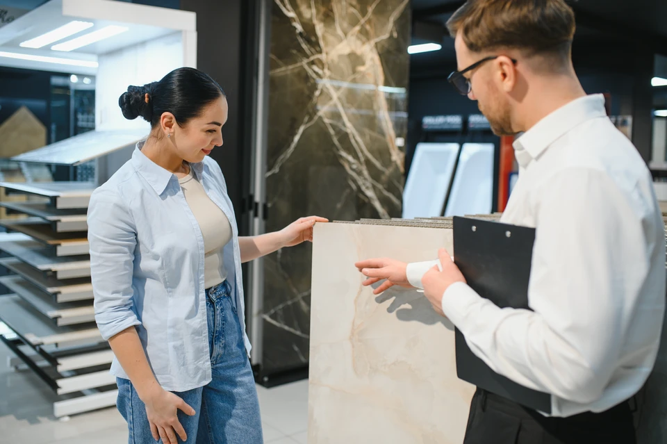 Consultant Femme vendeuse conseillant la cliente avec des échantillons de couleur et de texture pour la salle de bain