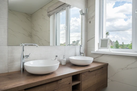 Salle de bain moderne luxueuse avec vasque rectangulaire blanche, robinetterie chromée contemporaine, plan de toilette en marbre blanc veiné